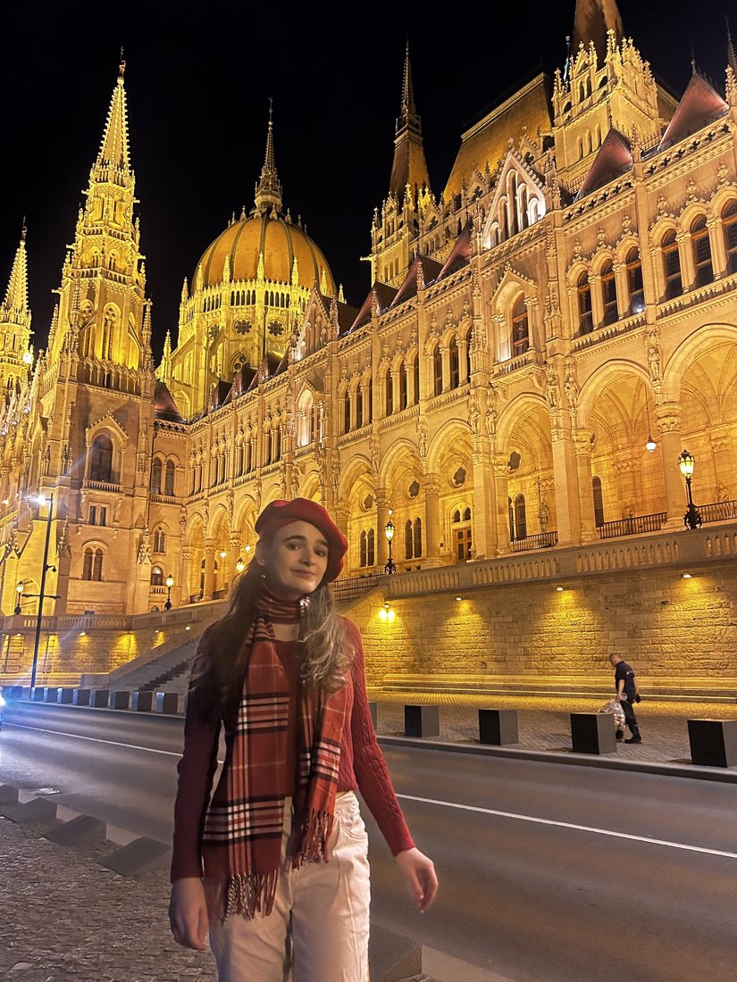 At night in front of the lit Hungarian Parliament Building.