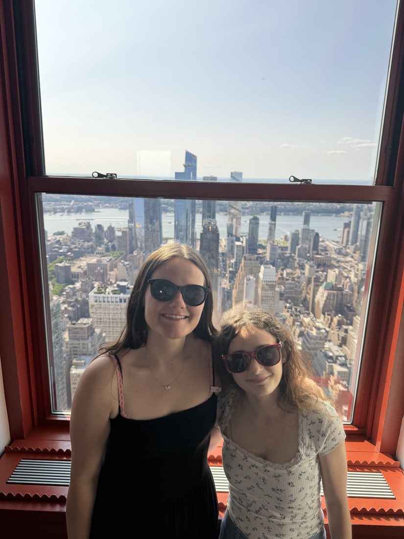 At a window near the top of the Empire State Building, Manhattan below.