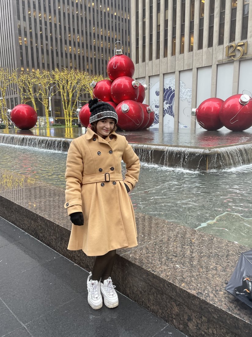 By the giant red Christmas ornaments on Sixth Avenue in Manhattan.